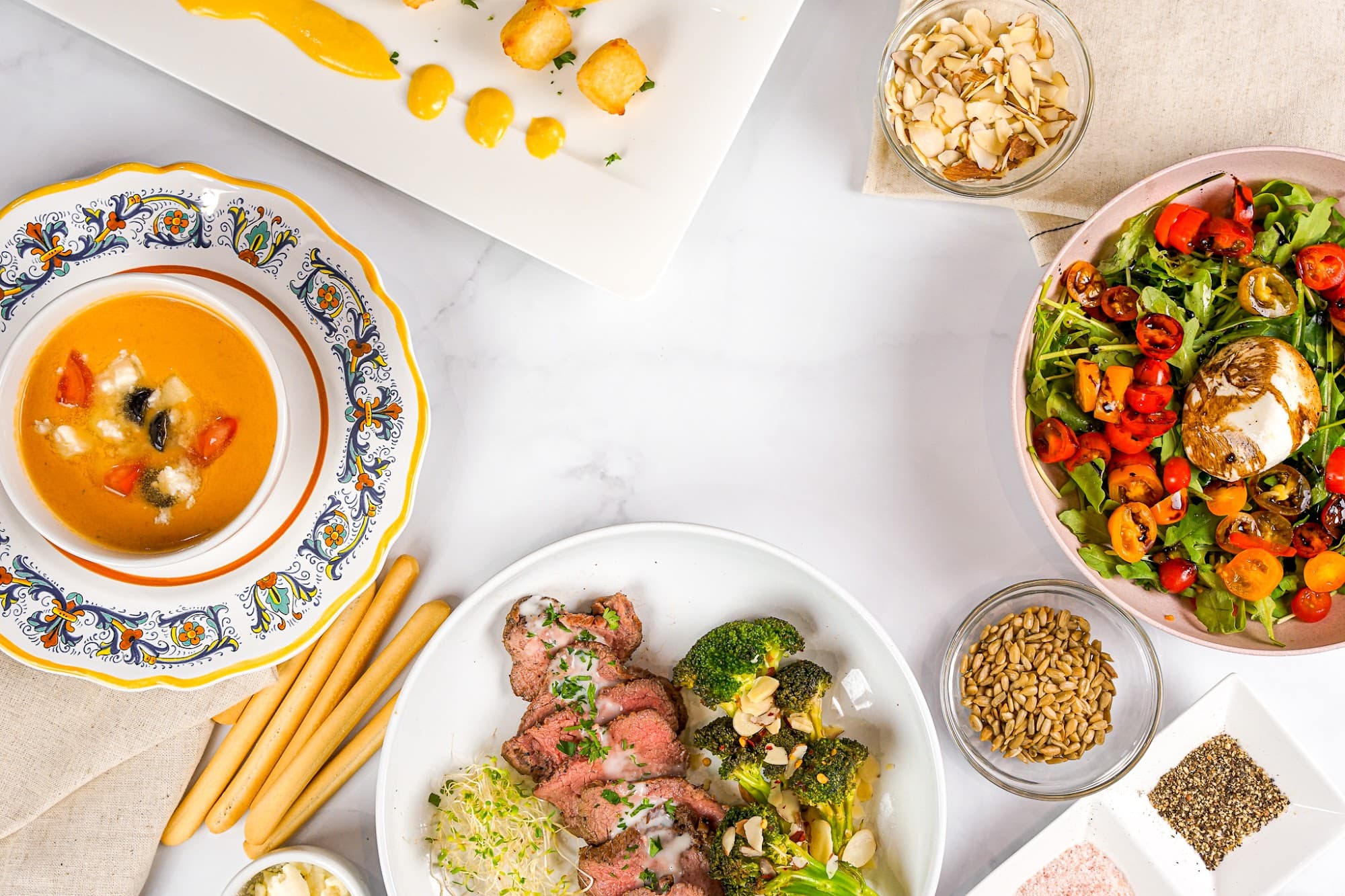 An overhead spread of multiple plated courses by a private chef in Atlanta