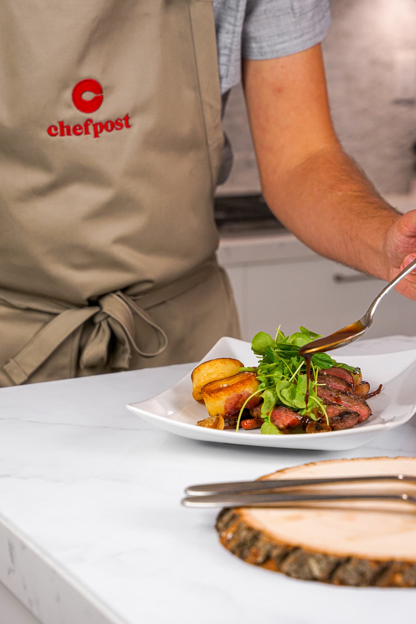 A private chef plating a course at the counter in a Jersey City kitchen