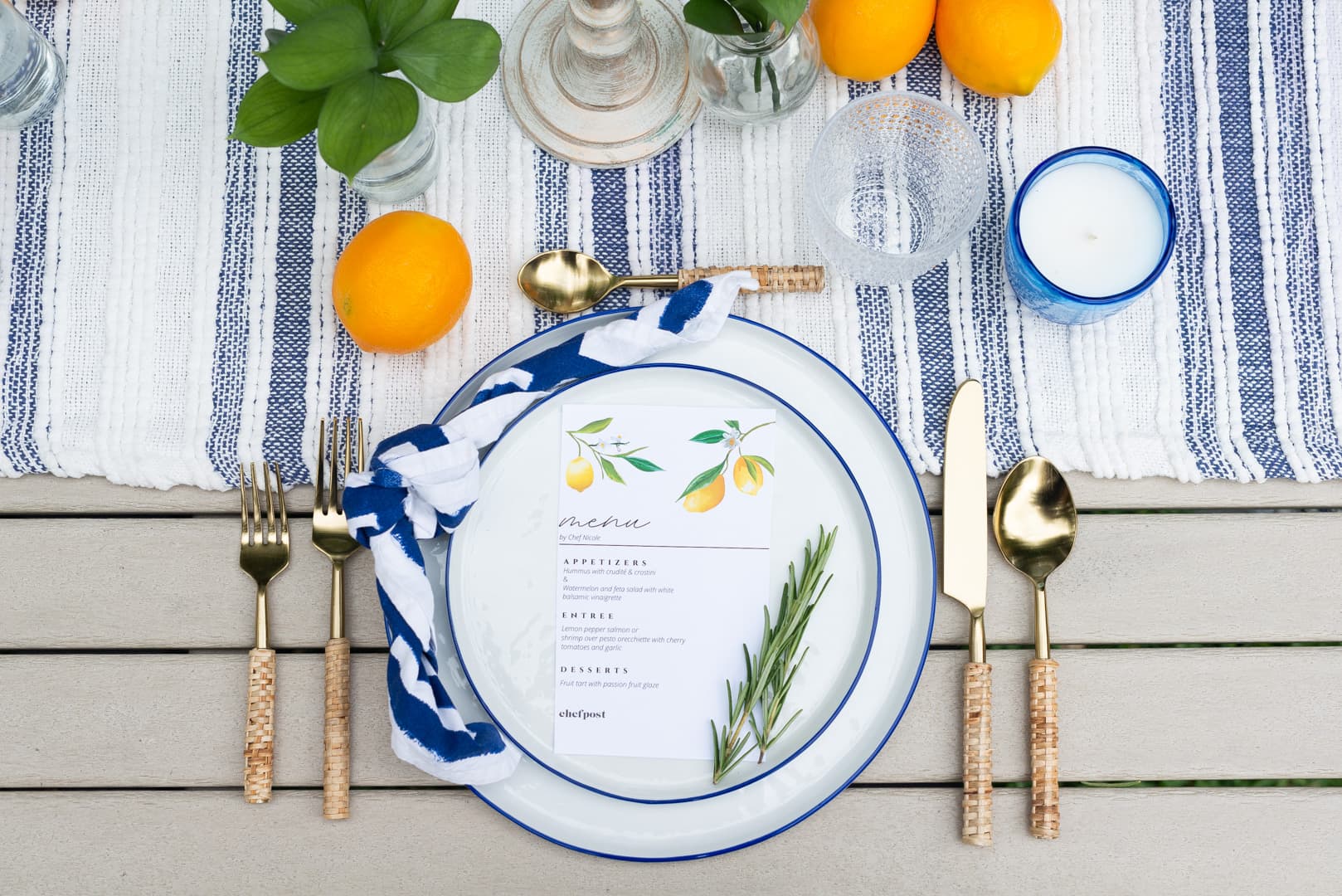 A blue and white coastal place setting with a menu card and rosemary set by a private chef in Fort Lauderdale