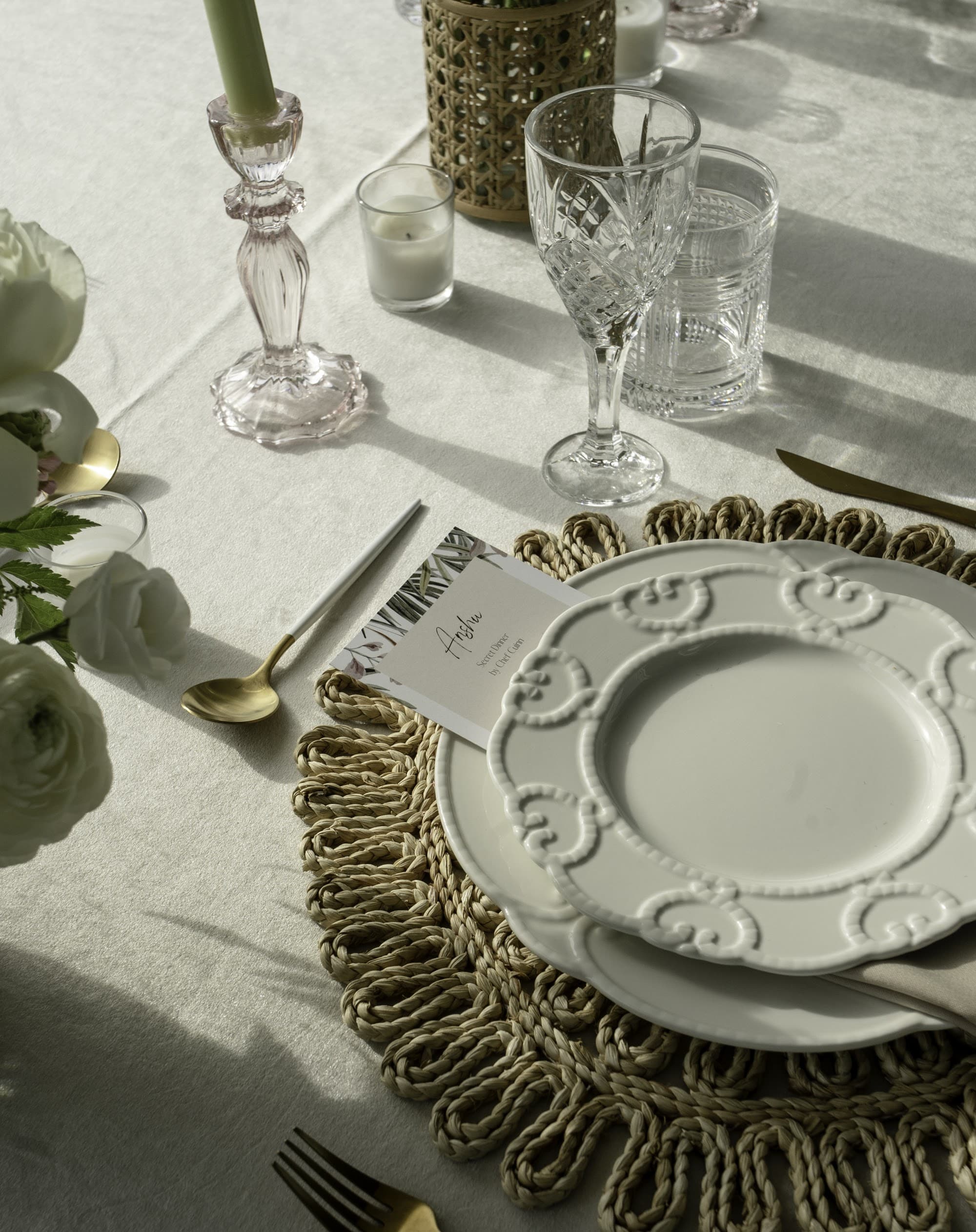 An elegant neutral place setting with a fringed placemat and gold cutlery, set by a private chef in Bal Harbour