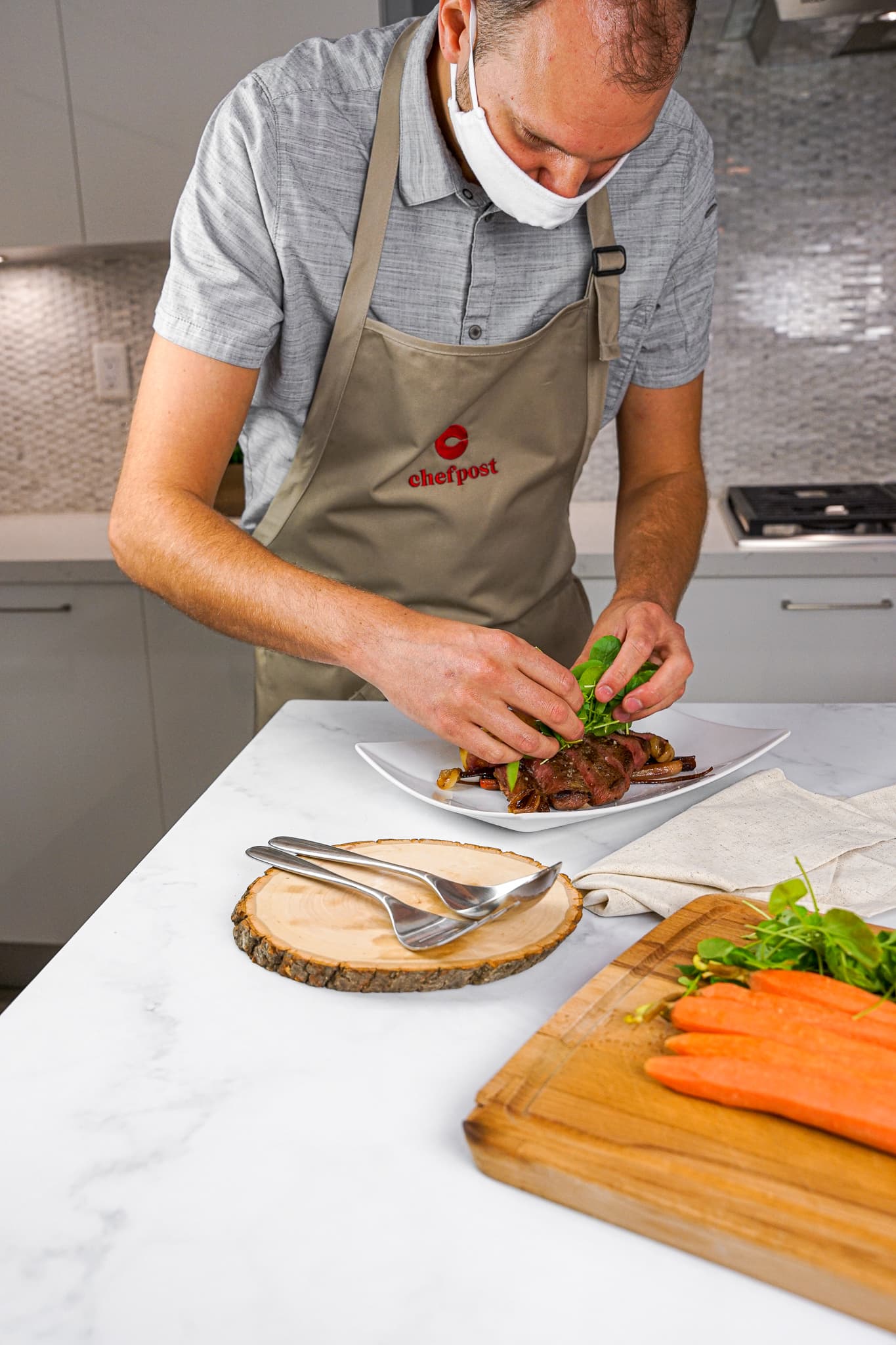 A private chef plating a course at the kitchen counter in a Jersey City home
